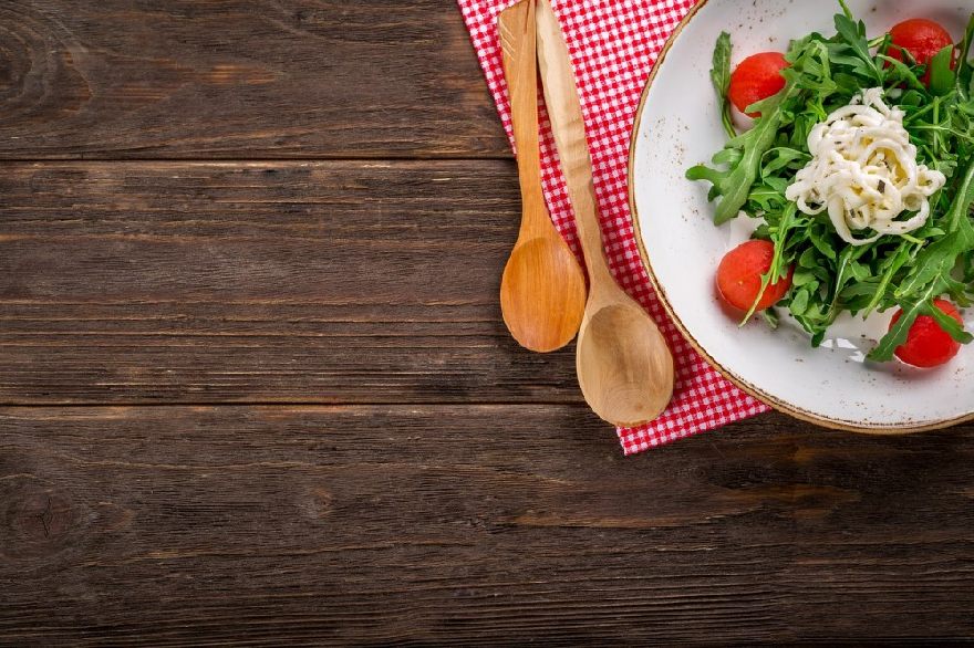 Salatteller auf Holztisch angerichtet wie beim Restaurant Milano mit orginal italienischer Pizza und Pasta sowie Lieferdienst für Herzebrock-Clarholz.